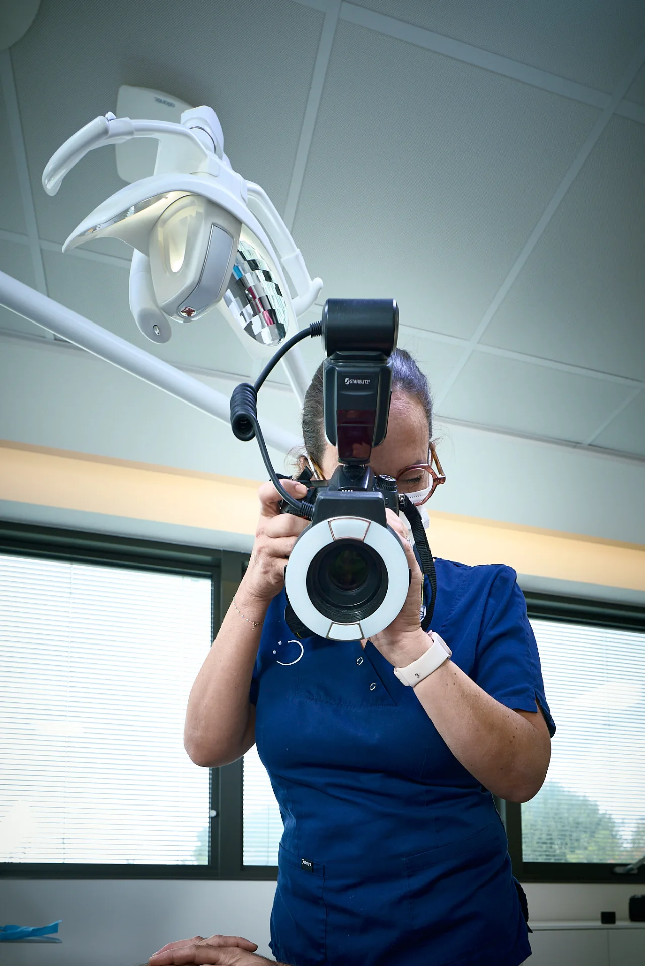 Praticienne avec boîtier reflex et flash annulaire